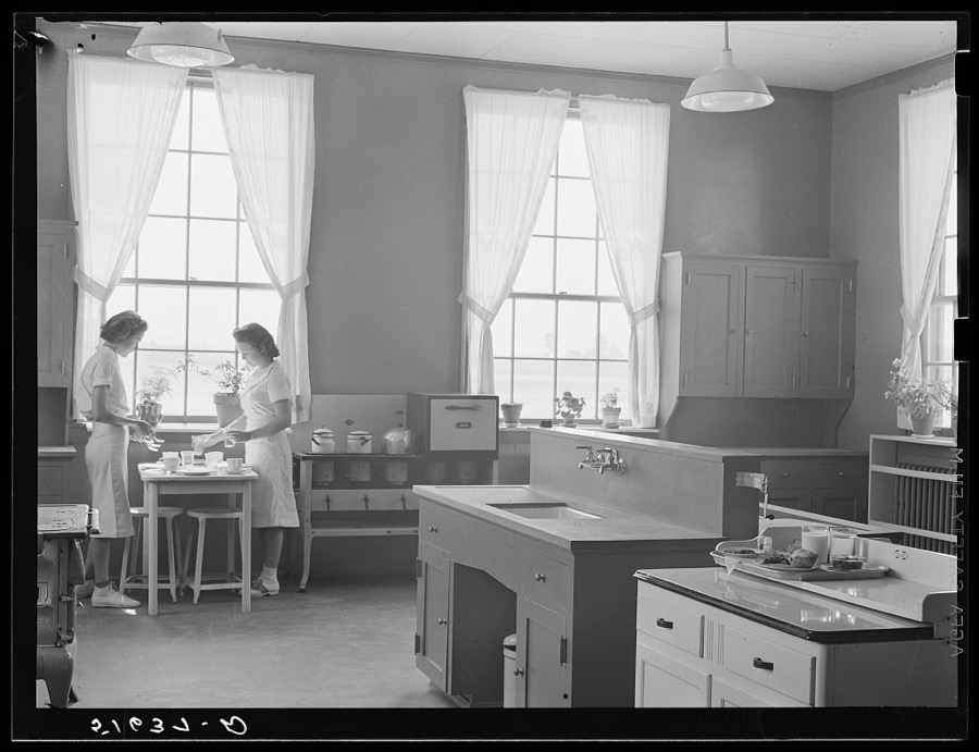 Dorothy Smith and Elizabeth Atkinson setting table in home economics room in school building. Ashwood Plantations, South Carolina
