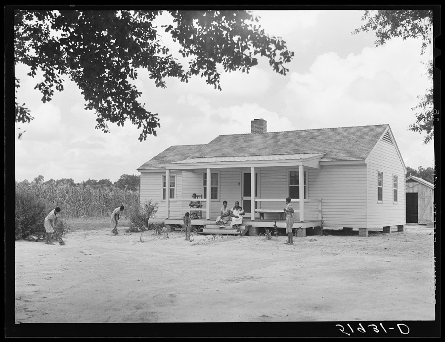 Children of Frederick Oliver, tenant purchase client, sweeping yard in front of new home. Summerton, South Carolina