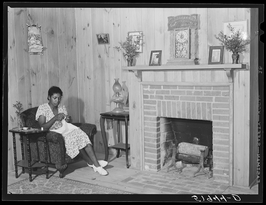 Daughter of Frederick Oliver, tenant purchase client, sewing in living room of new home. Summerton, South Carolina