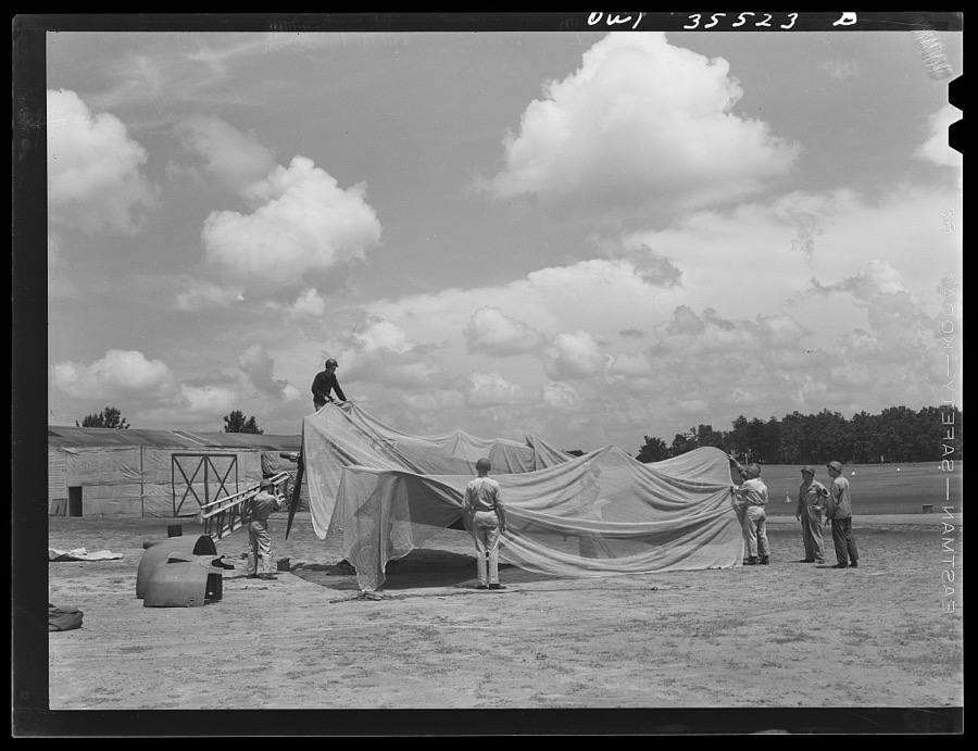 Greenville, South Carolina. Air Service Command. Men of the 35th service squadron of the 25th service group, spreading camouflage netting over a plane