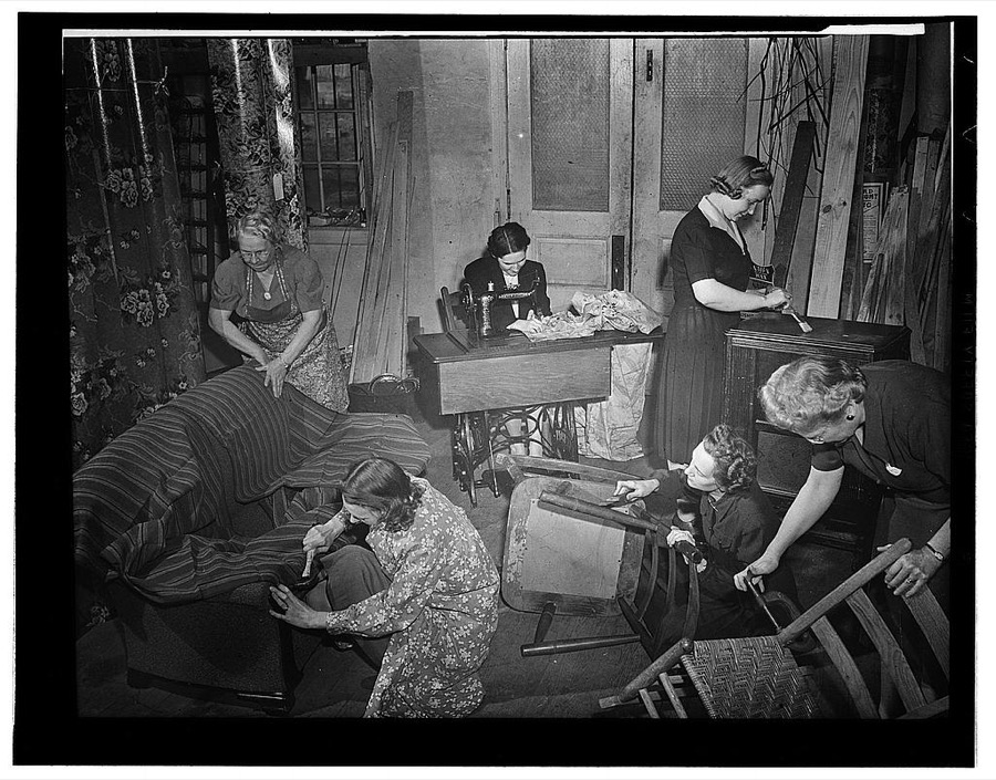York, South Carolina. York Red Cross workers agreed to furnish four dayrooms at Fort Jackson, ninety miles from York; they sent out a call for discarded household furnishings, repaired and repainted them in the rear of a Main Street store. Shown here, left to right, are: Mrs. Emil Montgomery, Mrs. Annie O'Leary, Mrs. George Smith (sewing), Mrs. Nearl Hanks, (at radio), Mrs. R.B. Hilderbrand, wife of the Mayor, (kneeling at a chair), And Mrs. W.W.Harrison, chairman of Camp and hospital service. The chapter