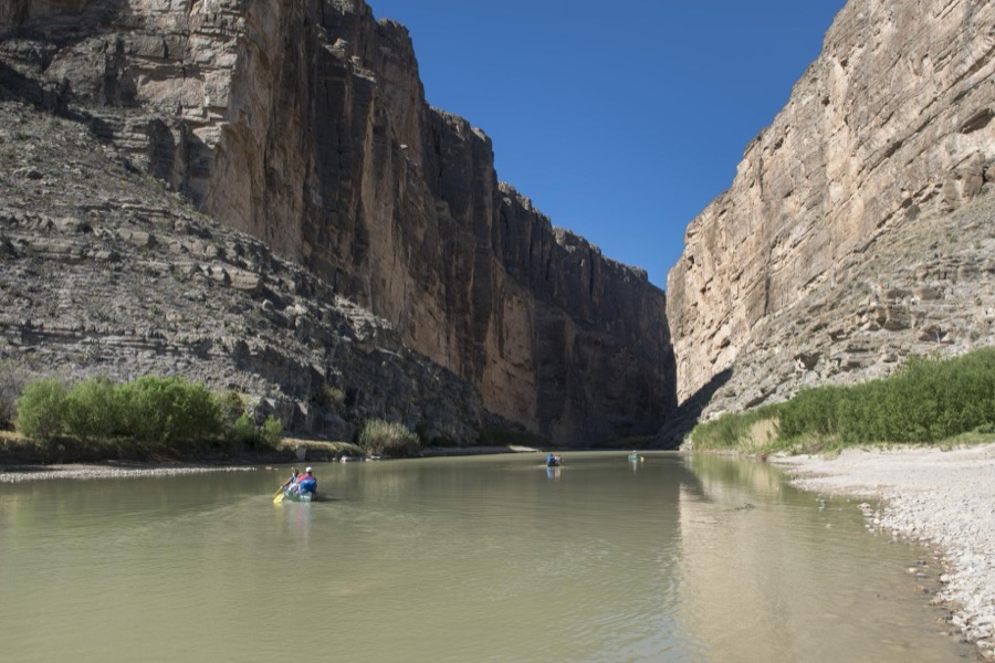 Canoers set off to navigate the Rio Grande River between the sheer rock faces of Santa Elena Canyon, deep in Big Bend National Park in Brewster County, Texas. Mexico is to the left, the United States to the right