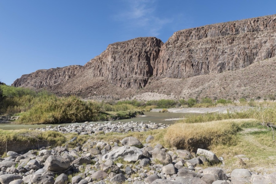 A view of the Rio Grande River, looking generally west, in Big Bend Ranch State Park, Brewster County, Texas. The rock formation to the right is in the United States, the sliver of green to the left in Mexico