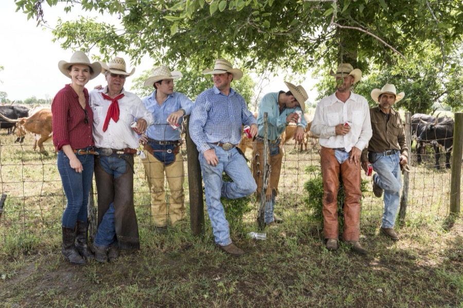 Cowhands, including cowgirl Lacey Elick Hollis, left, take a break from branding longhorns at the 1,800-acre Lonesome Pine Ranch, a working cattle ranch that is part of the Texas Ranch Life ranch resort near Chappell Hill in Austin County, Texas