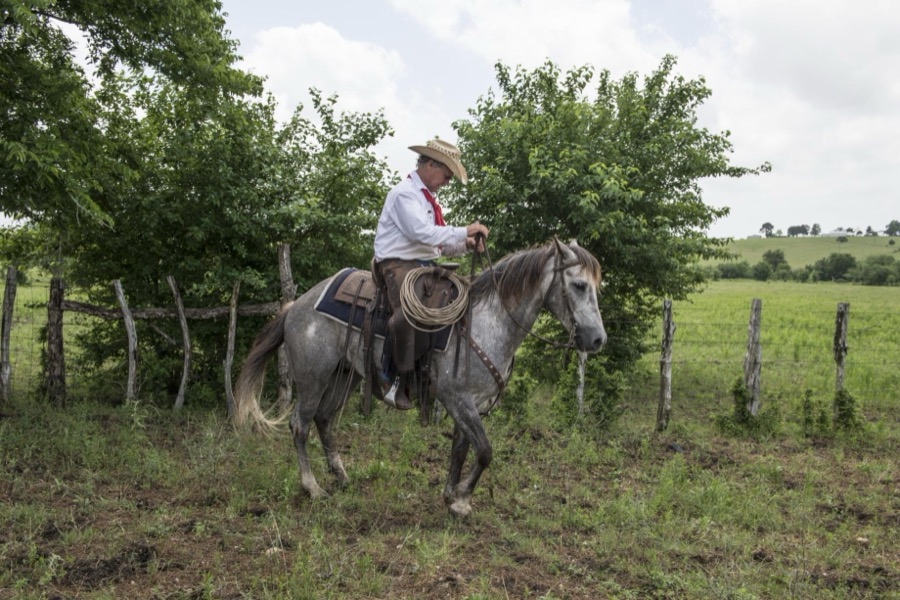 John Elick, owner of the 1,800-acre Lonesome Pine Ranch, atop his horse Rebelito at the working cattle ranch that is part of the Texas Ranch Life ranch resort near Chappell Hill in Austin County, Texas