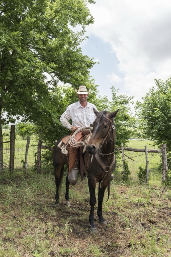 Cowhand E.B. Feldman, atop his horse, Deets, at the 1,800-acre Lonesome Pine Ranch, a working cattle ranch that is part of the Texas Ranch Life ranch resort near Chappell Hill in Austin County, Texas