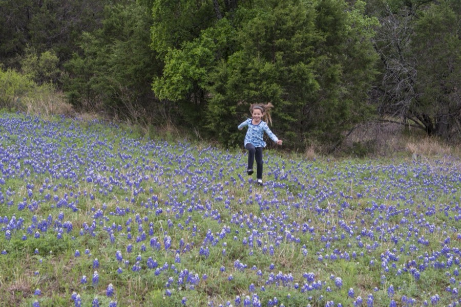 Kyndal Britt Peevey of Leander, Texas, skips through a field of bluebonnets near Inks Lake in the Texas Hill Country