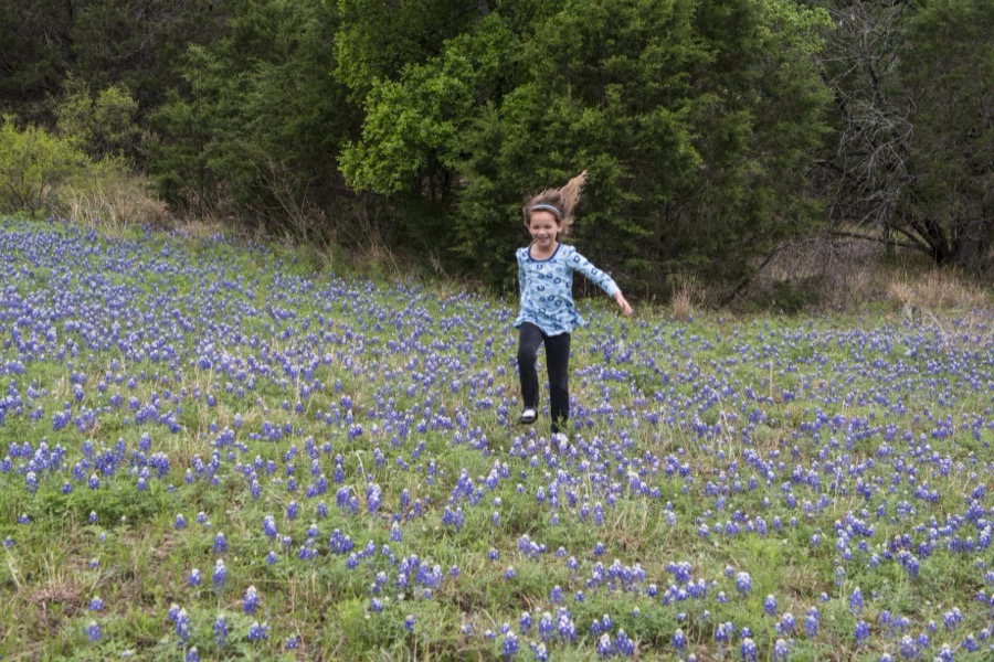 Kyndal Britt Peevey of Leander, Texas, skips through a field of bluebonnets near Inks Lake in the Texas Hill Country