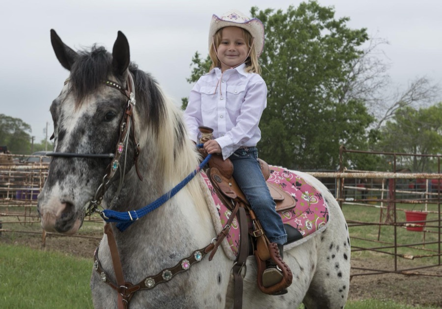 Naomi Brander, of San Antonio, aboard her horse Punch at the annual Poteet Strawberry Festival in Poteet, a small city in Atascosa County, Texas, near San Antonio. Naomi was one of the youngest contestants in the festival's "Bad Company Rodeo"
