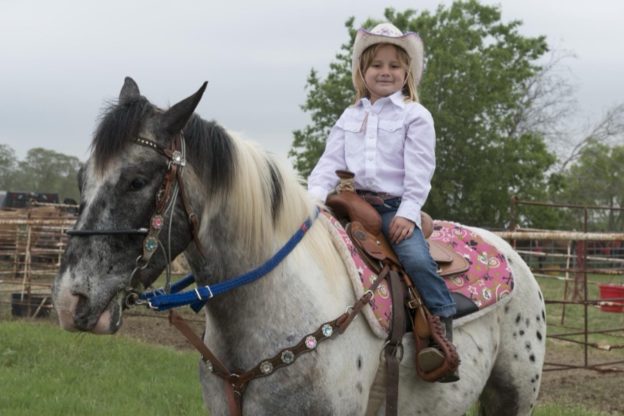 Naomi Brander, of San Antonio, aboard her horse Punch at the annual Poteet Strawberry Festival in Poteet, a small city in Atascosa County, Texas, near San Antonio. Naomi was one of the youngest contestants in the festival's "Bad Company Rodeo"