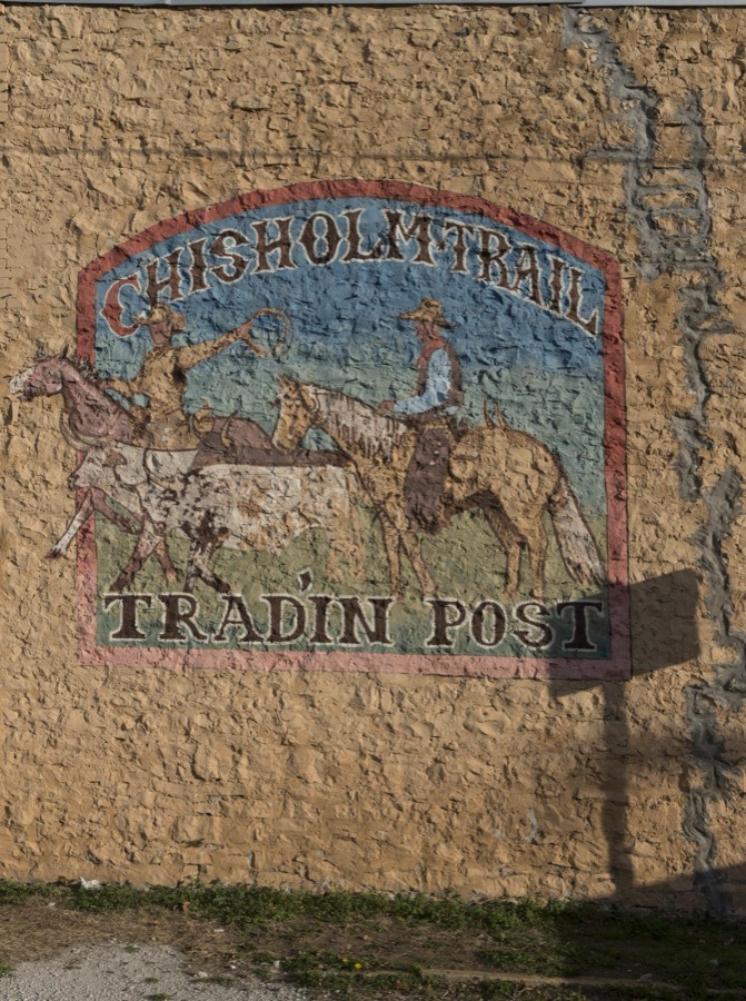 Faded advertising mural for the Chisholm Trail Tradin' Post in Meridian, a town in Bosque County, Texas