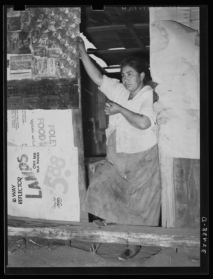 Mexican woman standing in doorway of kitchen. San Antonio, Texas. Notice the cardboard partitions