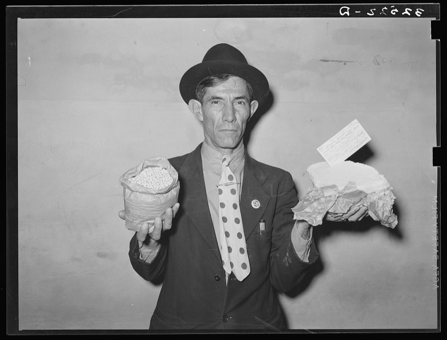 Mexican pecan workers union official displaying relief supplies which are supposed to feed a family of three for two weeks. The articles shown are beans and butter. San Antonio, Texas