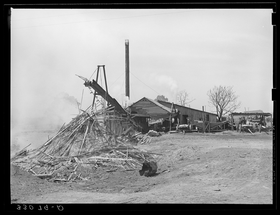 Sawmill and waste lumber pile being burned. Wells, Texas