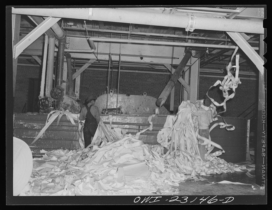 Lufkin, Texas. Southland paper mill. Placing trimmed edges of newsprint rolls into a vat where they are converted back into stock
