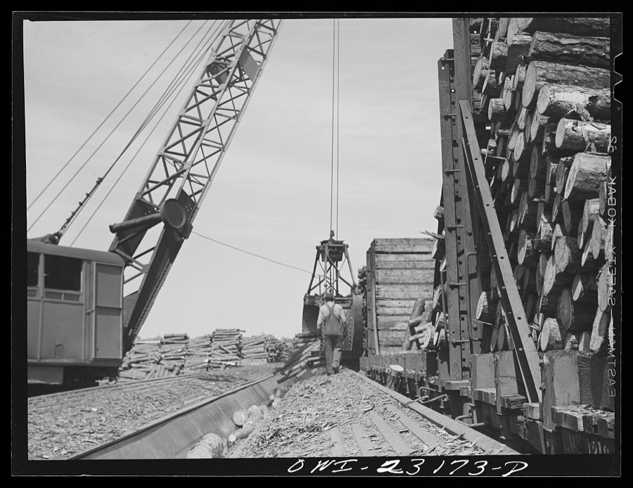 Lufkin, Texas. Southland paper mill. Crane unloading flat car of pulpwood in the wood yard