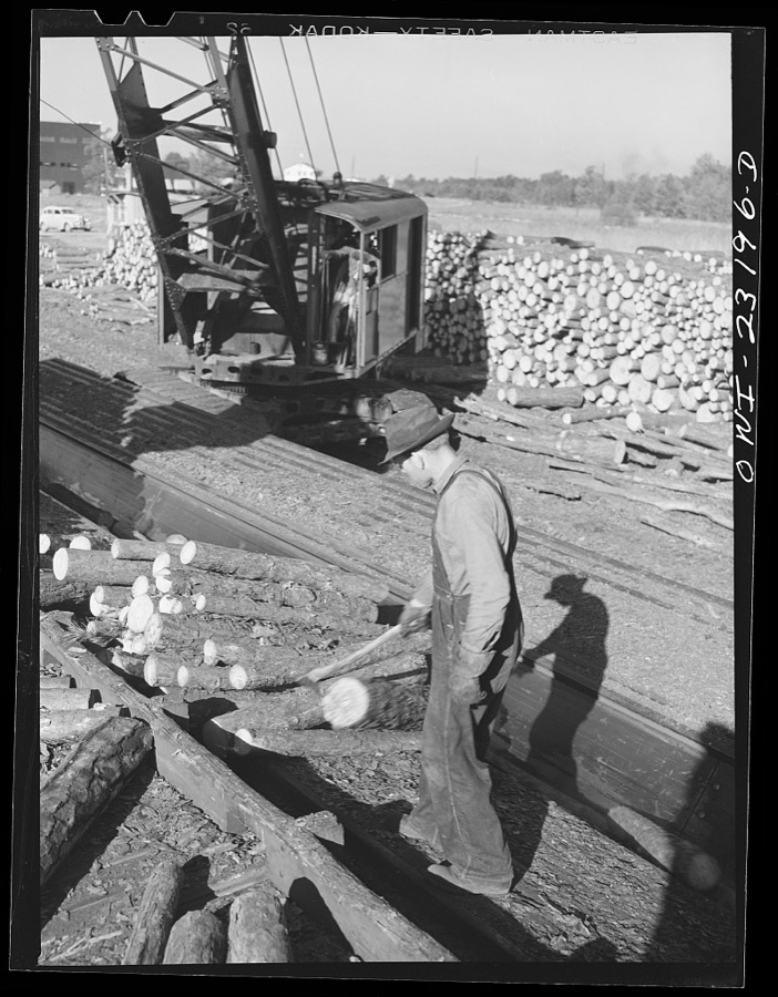 Lufkin, Texas. Southland paper mill. Crane unloading flat car of pulpwood in the wood yard