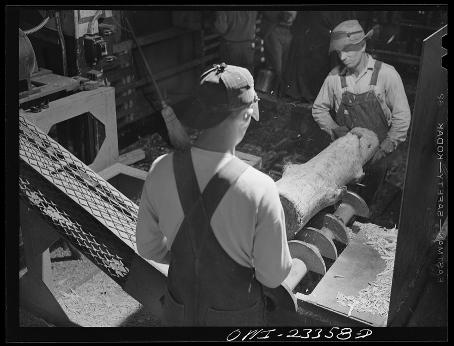 Lufkin, Texas. Southland paper mill. Log on the knotting machine. After the bark has been removed, knots are cut out of pulp logs which reduces the pitch content of the pulp
