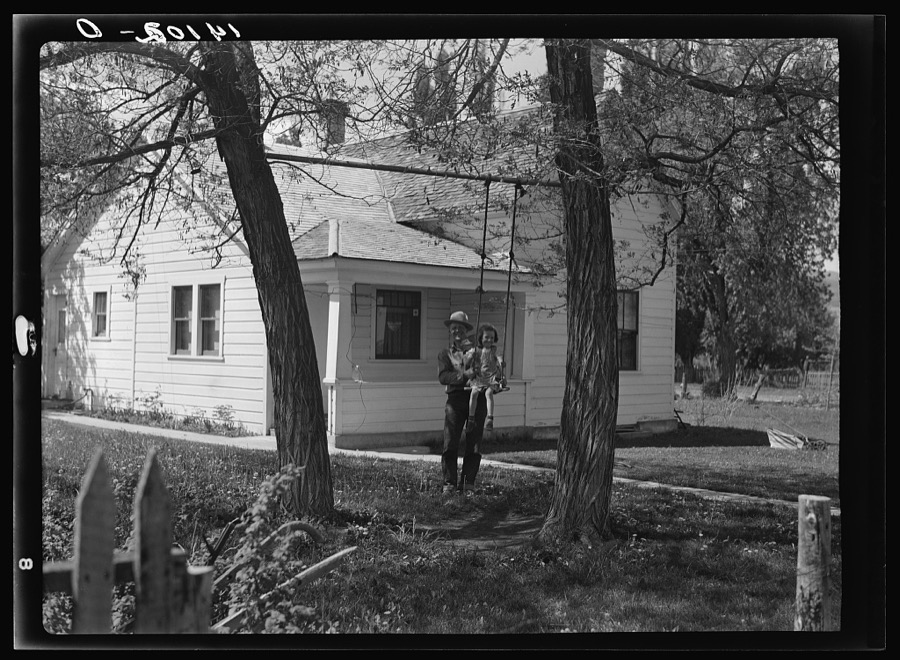 Marion Olsen of Paradise, Cache County, Utah, is a Farm Security Administration "graduate." He has borrowed and paid back twelve thousand dollars since 1936, and can now finance himself or get credit from his local bank. Olsen is shown with his little daughter in front of the family home, on which it was possible to spend three hundred dollars of farm profit for repairs this year