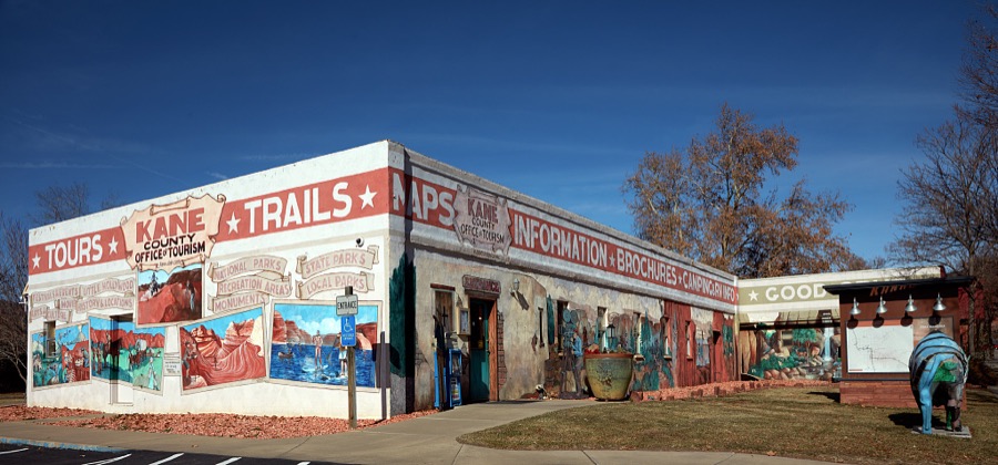 The Kane County Tourism Office in Kanab, a small city on the Arizona border in southern Utah, doesn't just talk or give visitors brochures about the town's rich history as the gathering place for producers, actors, and crews producing iconic western movies in the colorful canyons nearby, it illustrates that tradition on its exterior walls too