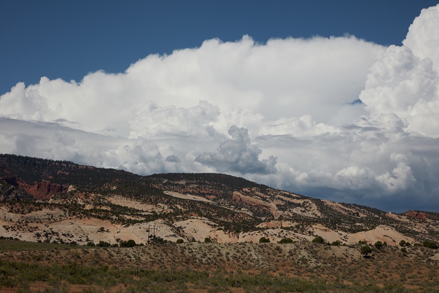 Clouds roil over a rugged hillside in Uintah County, near the Colorado border in northeast Utah, gradually turns from flaming red to creamy caramel