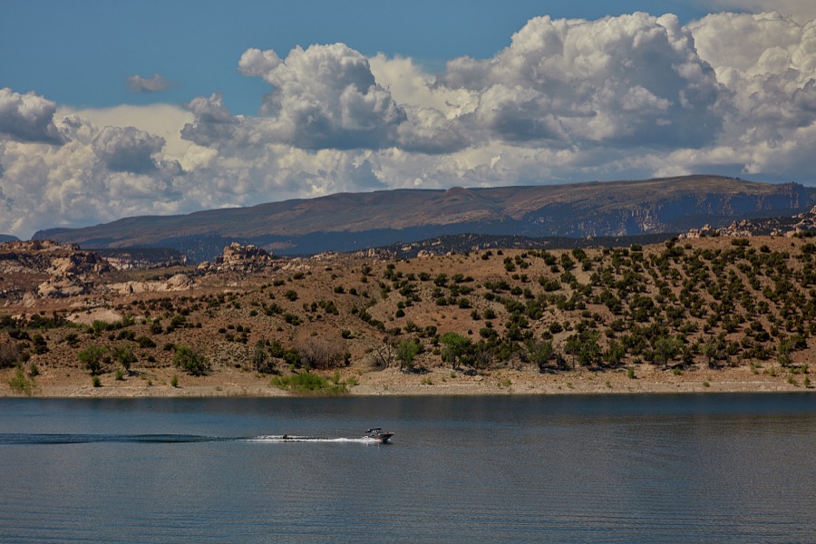 A speedboat pulls not a water skier but what appear to be two people in a single tube in the reservoir at Steinaker State Park, near Vernal, a small city in rugged Uintah County near the Colorado border in northeast Utah